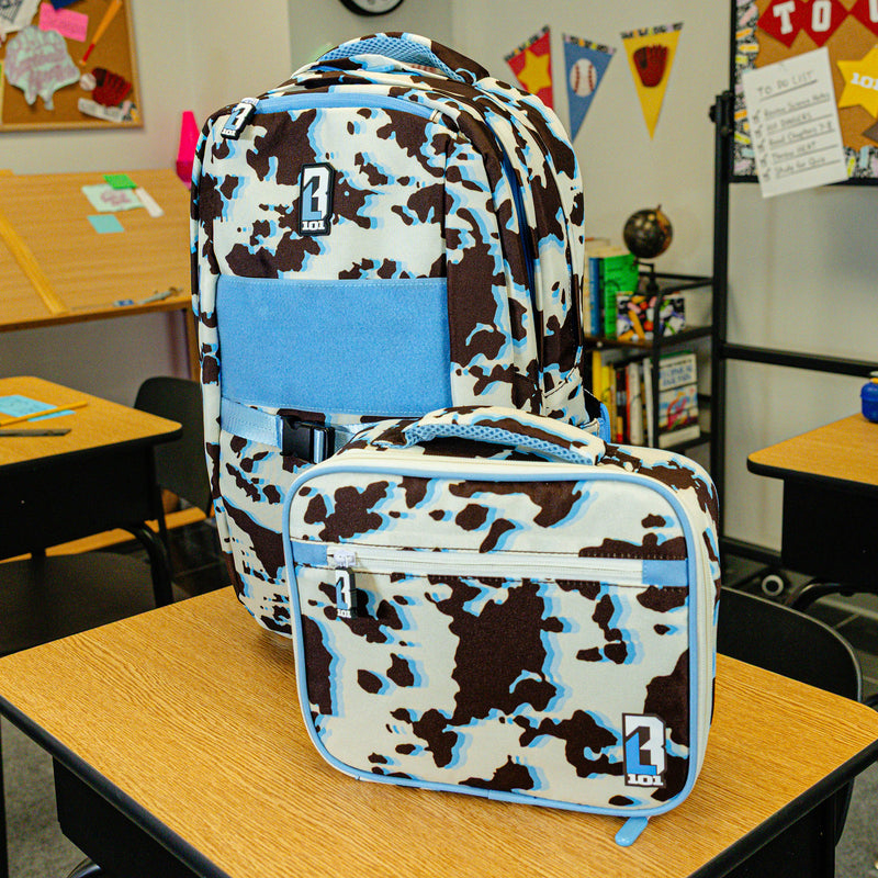 Adult model wearing multi-color lunch box with "Cowhide Curveball SZN 2" design