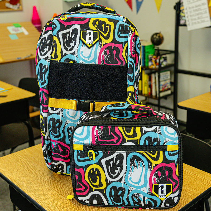 Adult model wearing multi-color lunch box with "Smiley Slugger SZN 2" design