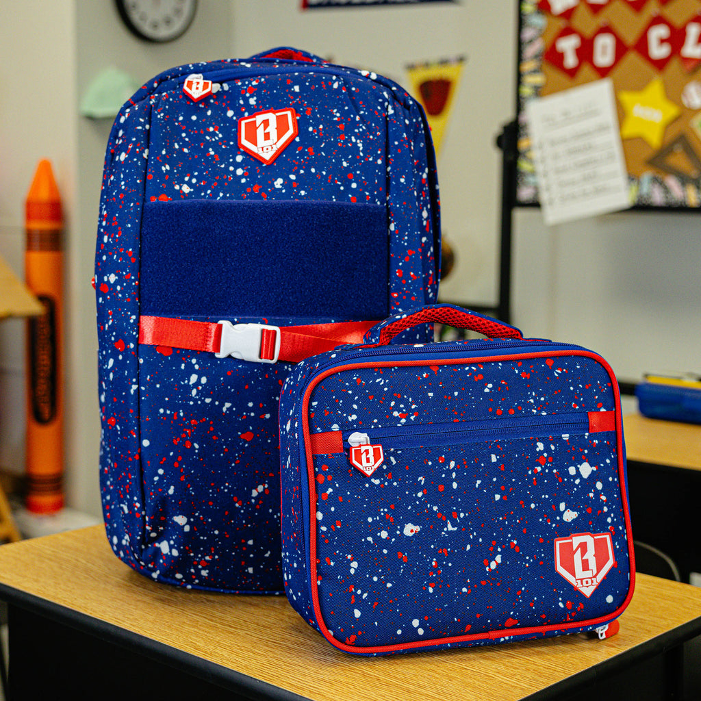 Adult model wearing blue lunch box with "Splatter SZN 2" design