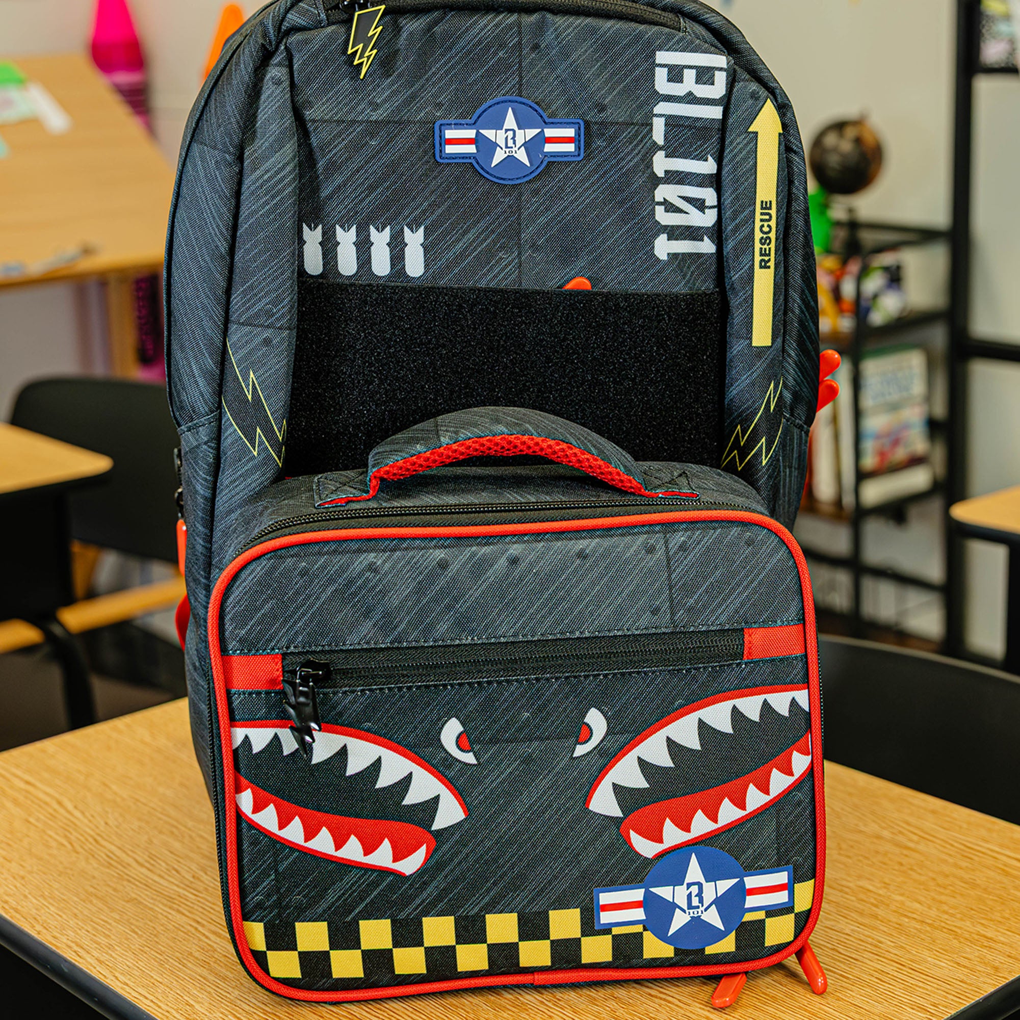 Adult model wearing multi-color lunch box with "Unit 101 SZN 2" design