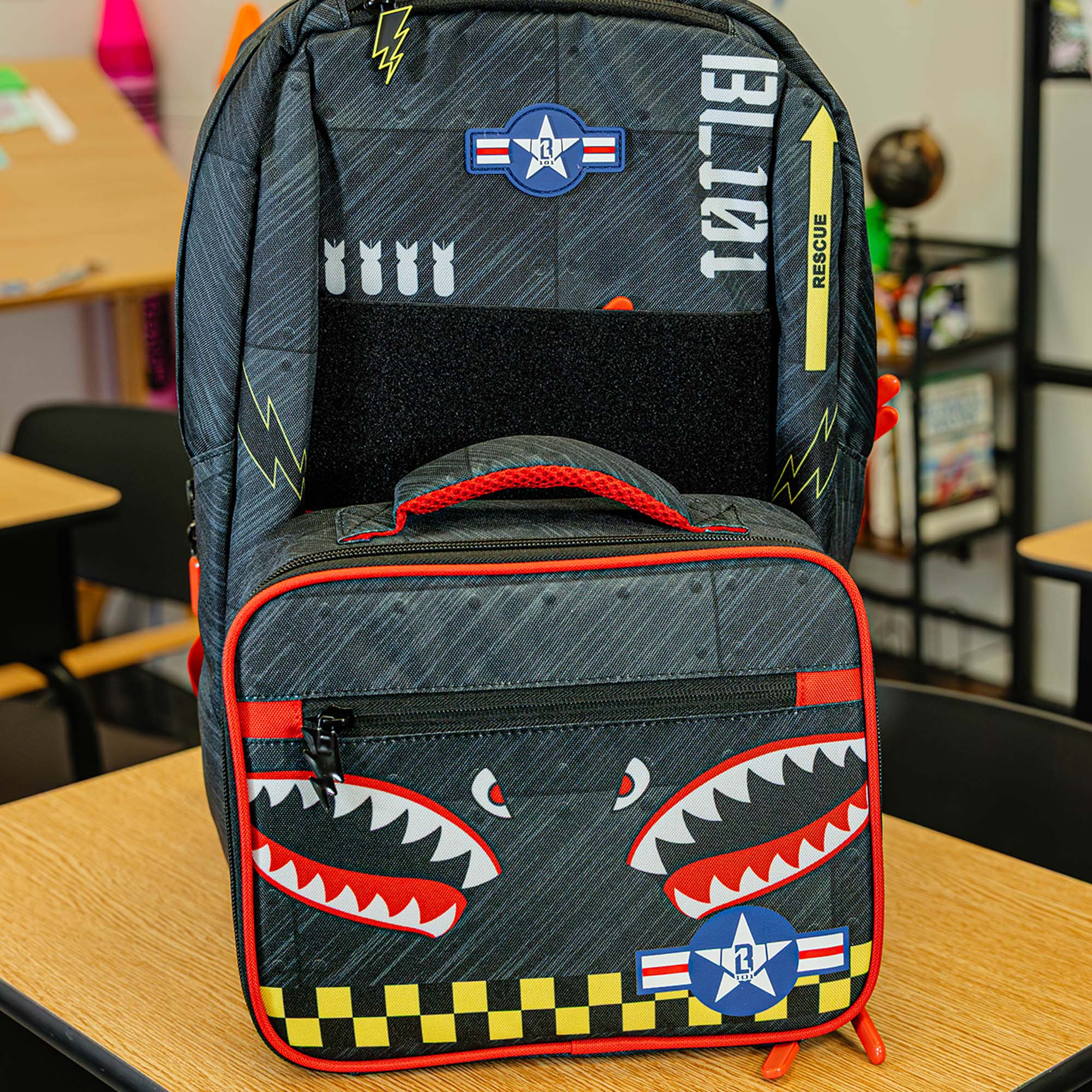 Adult model wearing multi-color backpack with "Unit 101 SZN 2" design