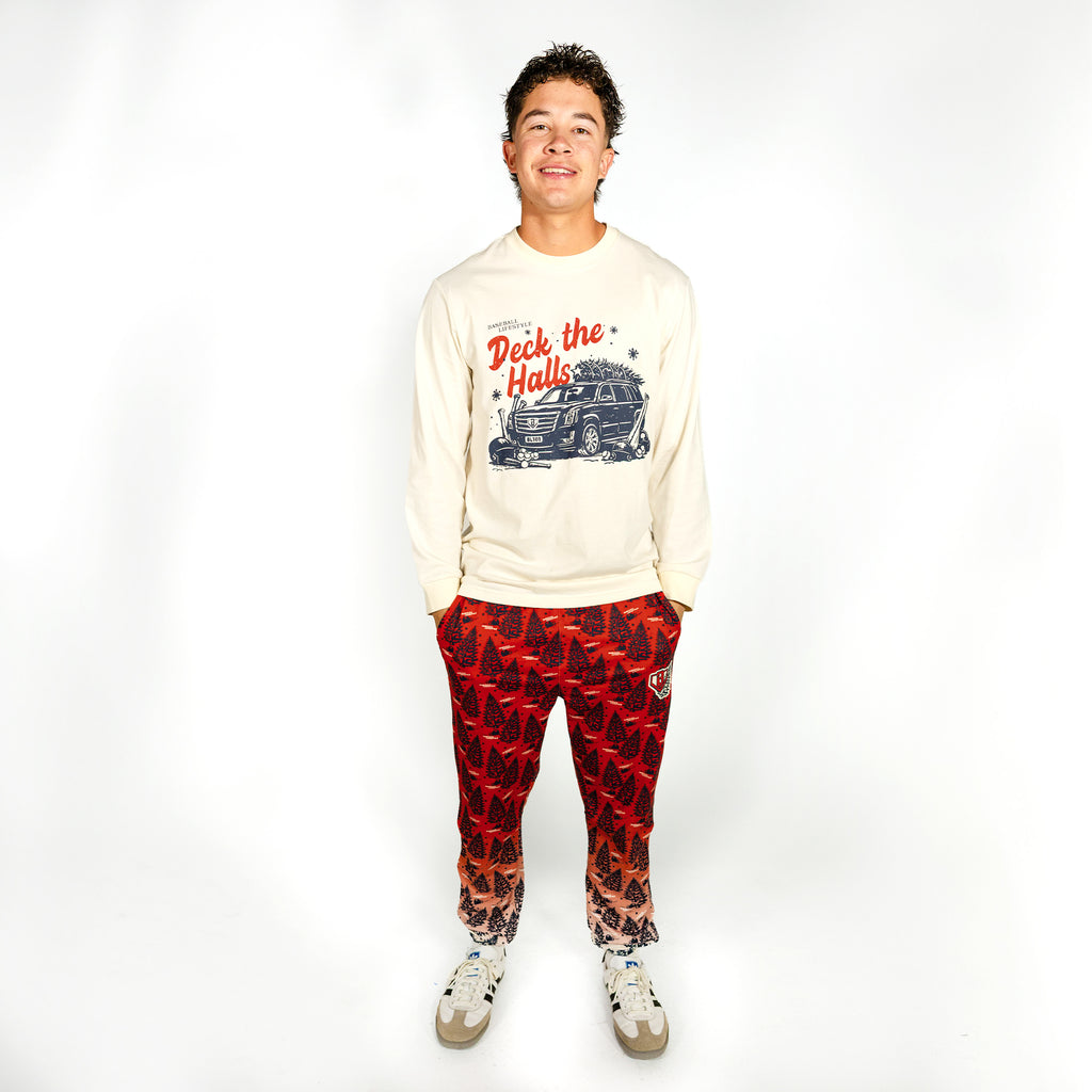 Adult model wearing red pajama pants with "Deck The Halls" design