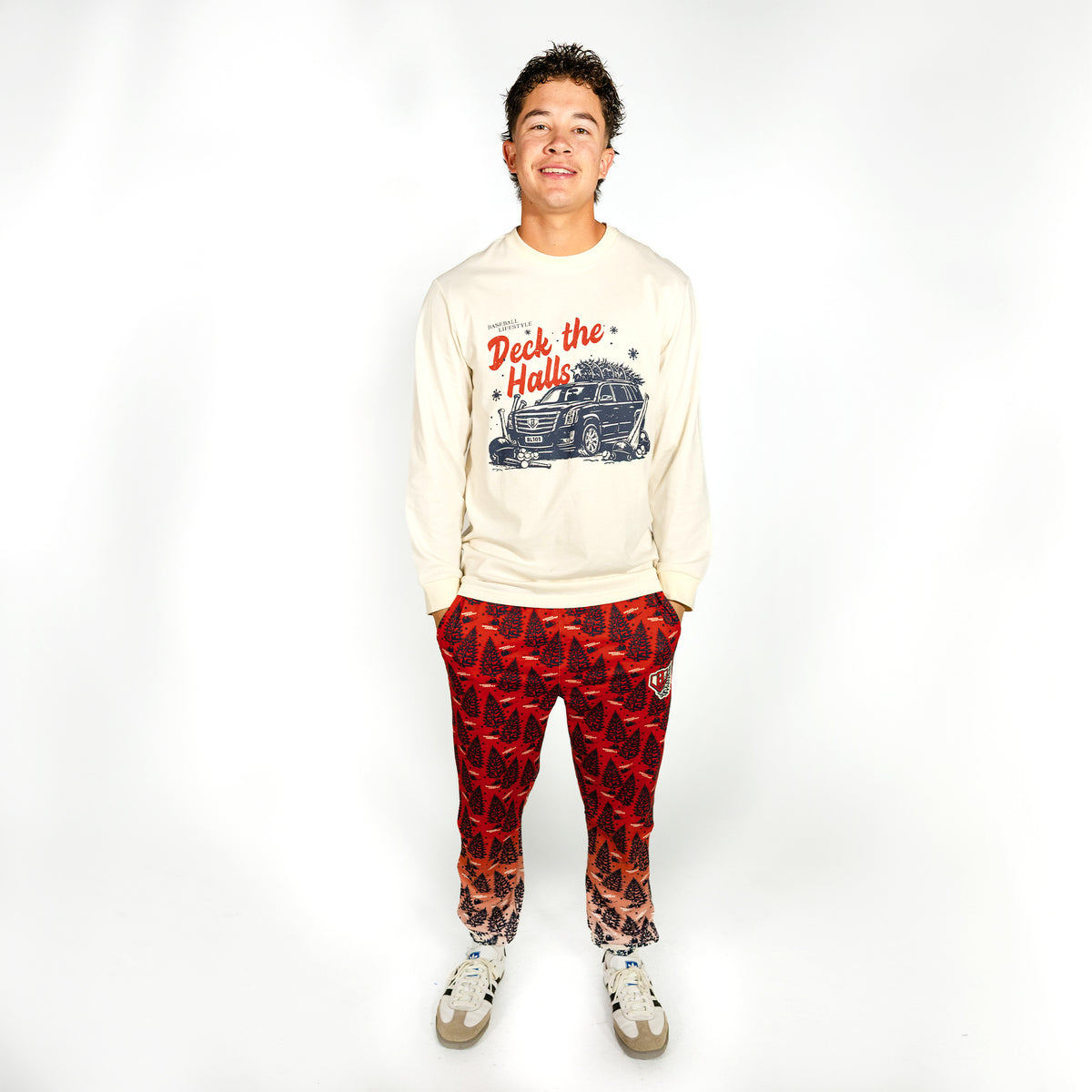 Adult model wearing red pajama pants with "Deck The Halls" design