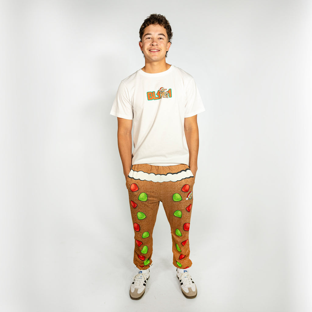 Adult model wearing brown pajama pants with "Gingerbread Rookie" design
