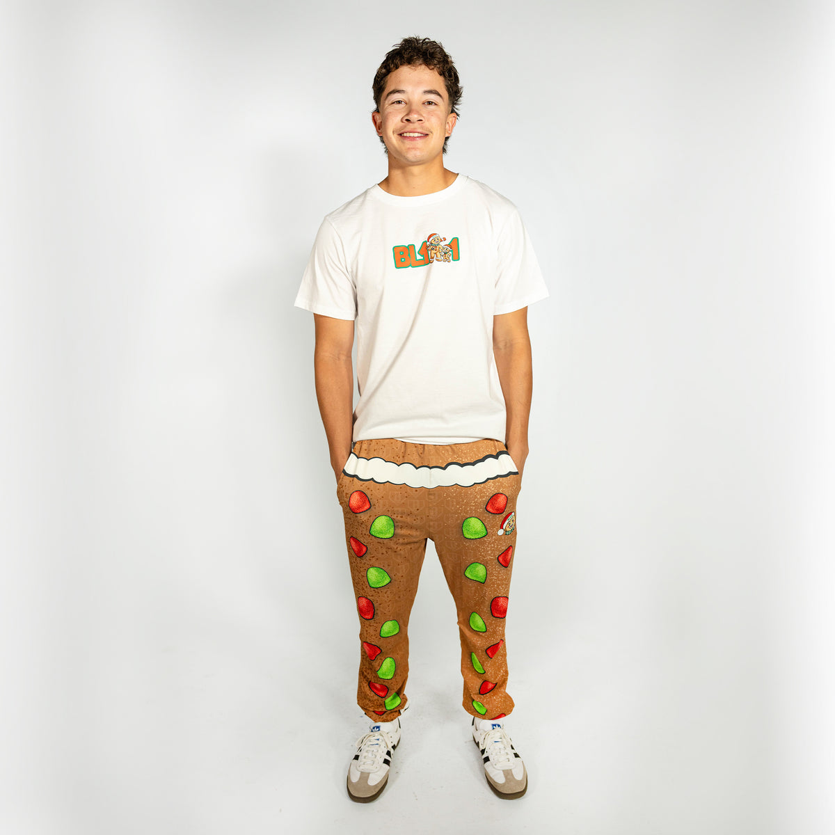Adult model wearing brown pajama pants with "Gingerbread Rookie" design