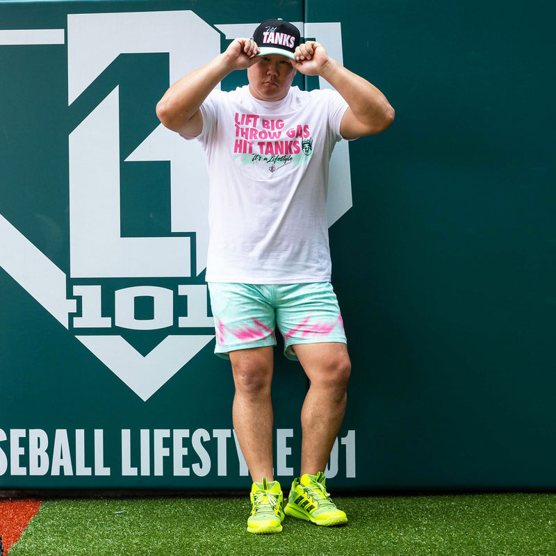 Adult model wearing teal shorts with "Hit Tanks" design
