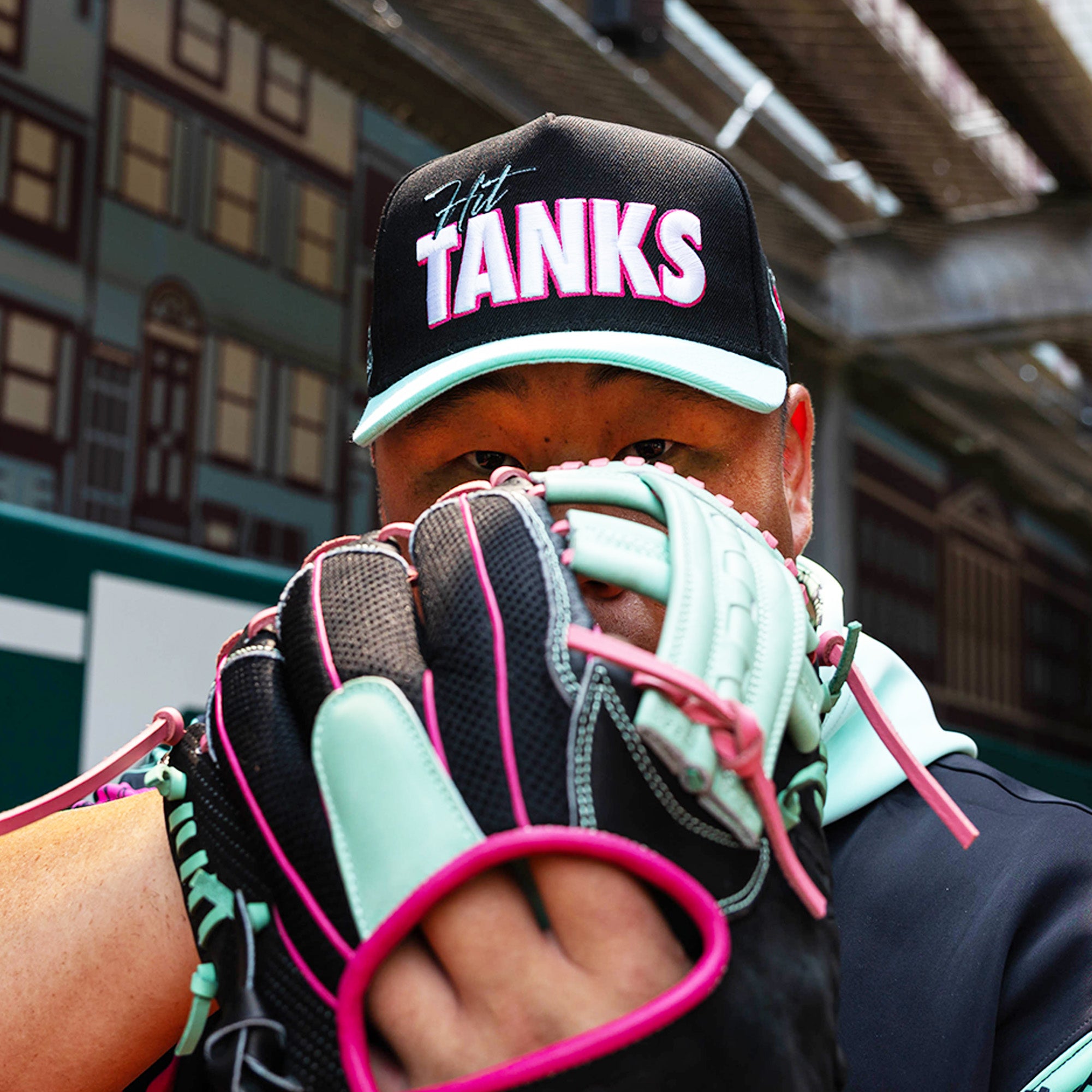 Adult model wearing black hat with "Hit Tanks" design