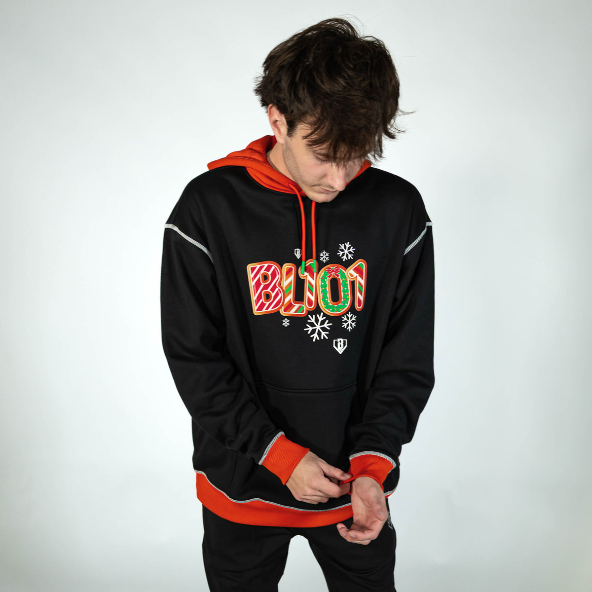 Adult model wearing black hoodie with "Holiday Cookie" design