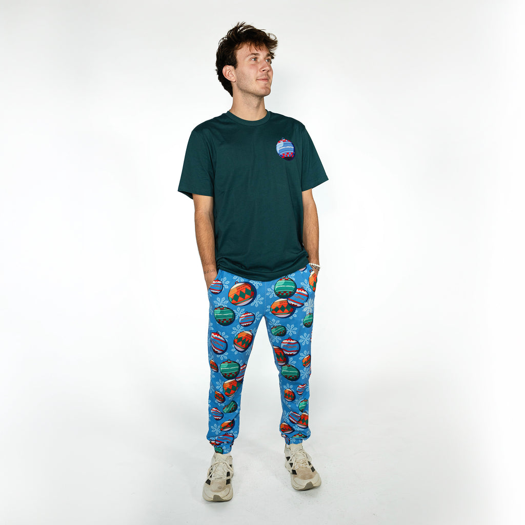 Adult model wearing blue pajama pants with "Jingle Ballers" design