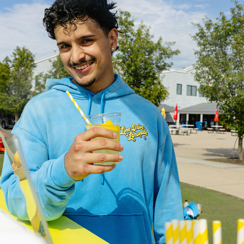 Adult model wearing blue hoodie with "Lemonade Cup" design
