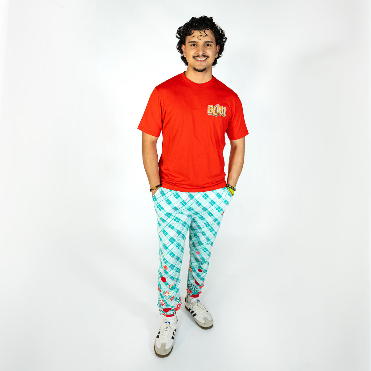 Adult model wearing multi-color pajama pants with "Peppermint Plaid" design