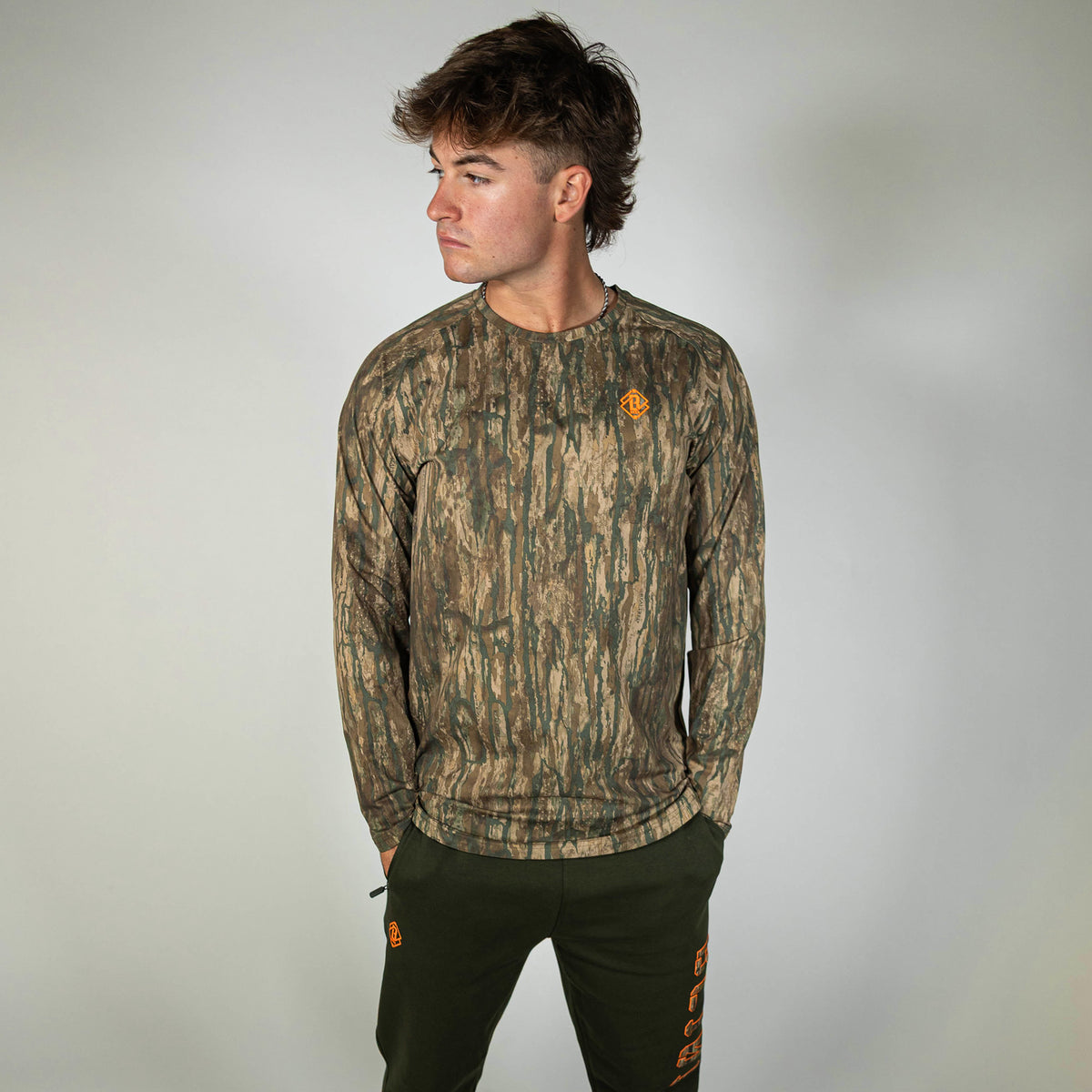 Adult model wearing multi-color Realtree Legacy Diamond Tech Camo long sleeve