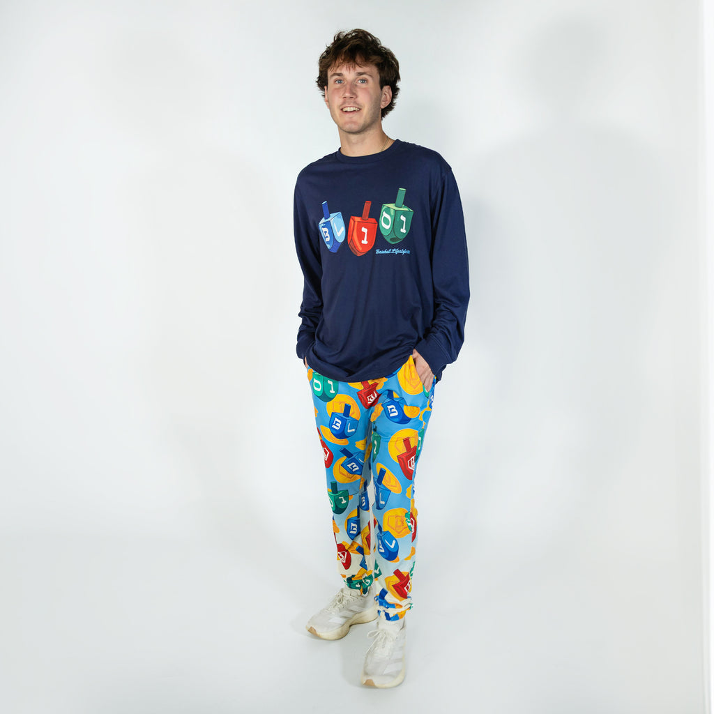 Adult model wearing blue pajama pants with "Spin & Swing" design