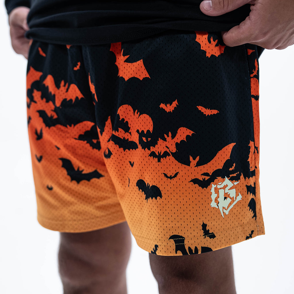 Adult model wearing orange shorts with "Bat Gradient" design