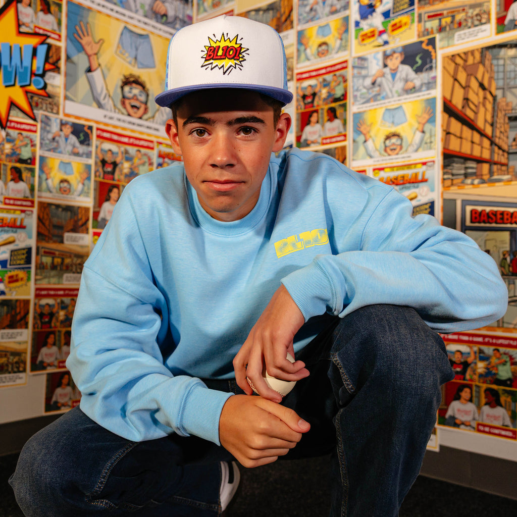 Adult model wearing blue crewneck with "Comic Collage" design