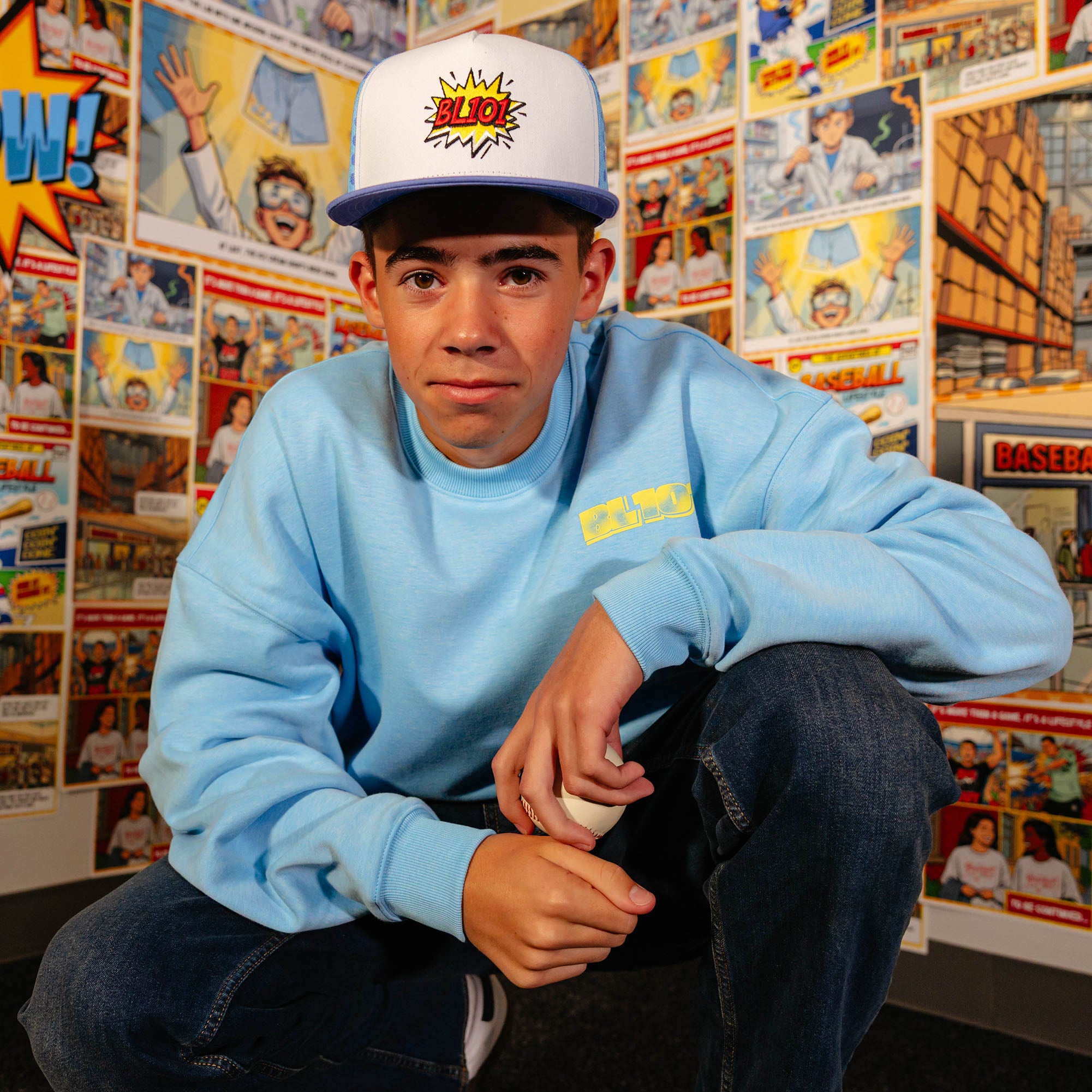 Adult model wearing blue crewneck with "Comic Collage" design