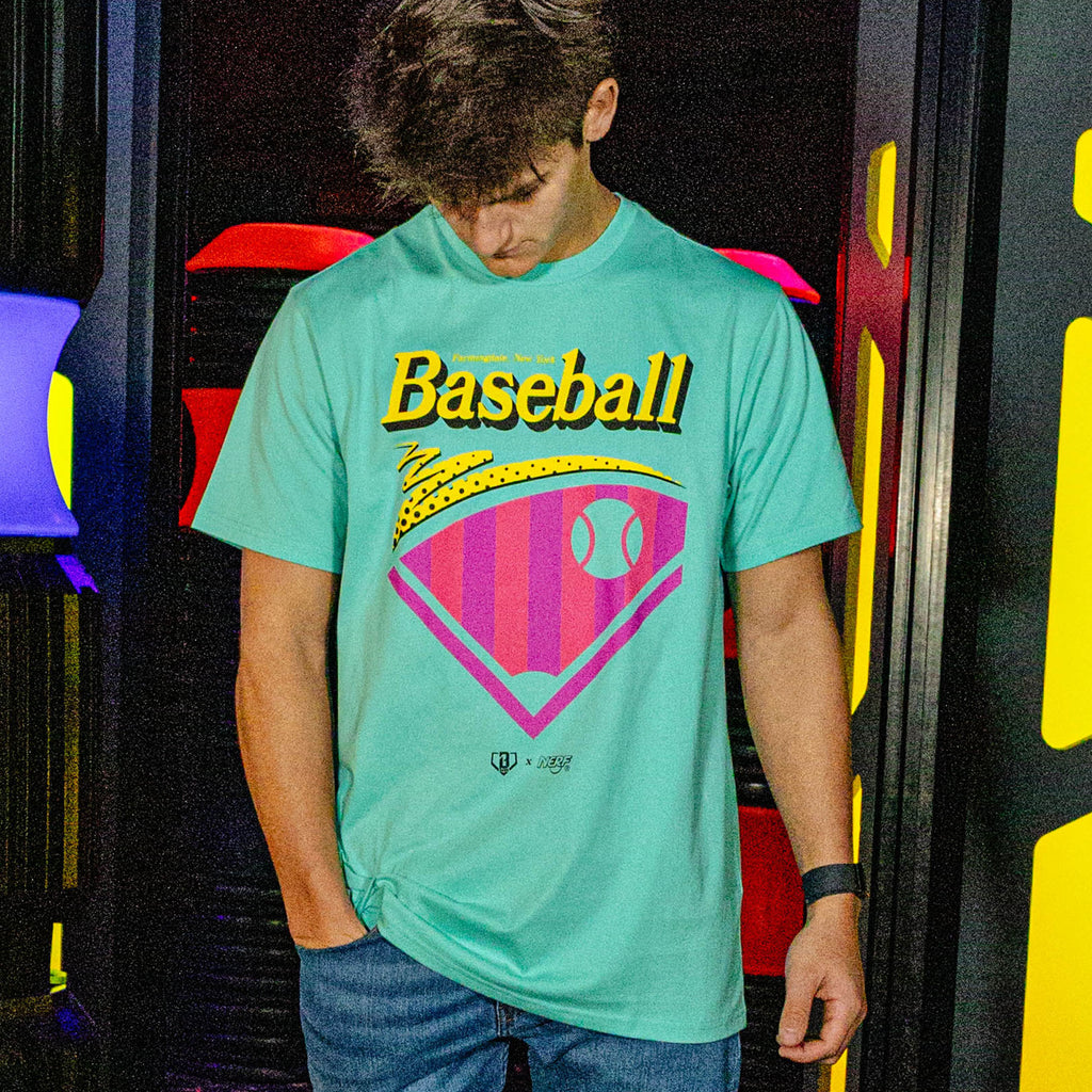 Person wearing a teal t-shirt with 'Baseball' graphic design in front of colorful background