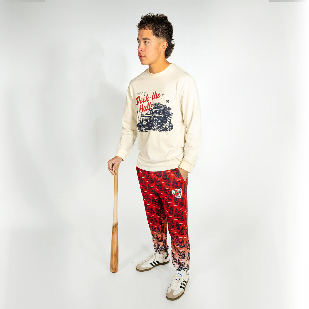 Adult model wearing red pajama pants with "Deck The Halls" design
