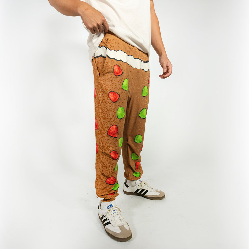 Adult model wearing brown pajama pants with "Gingerbread Rookie" design