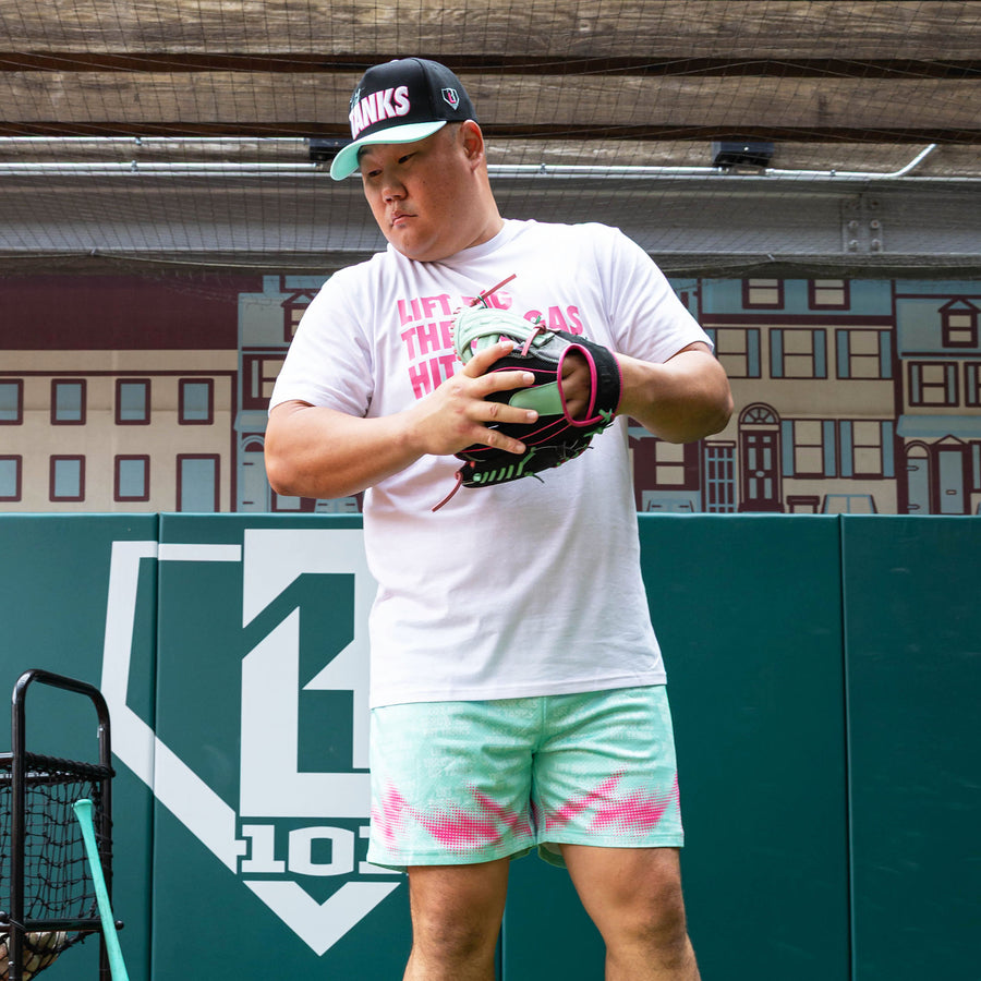 Adult model wearing teal shorts with "Hit Tanks" design