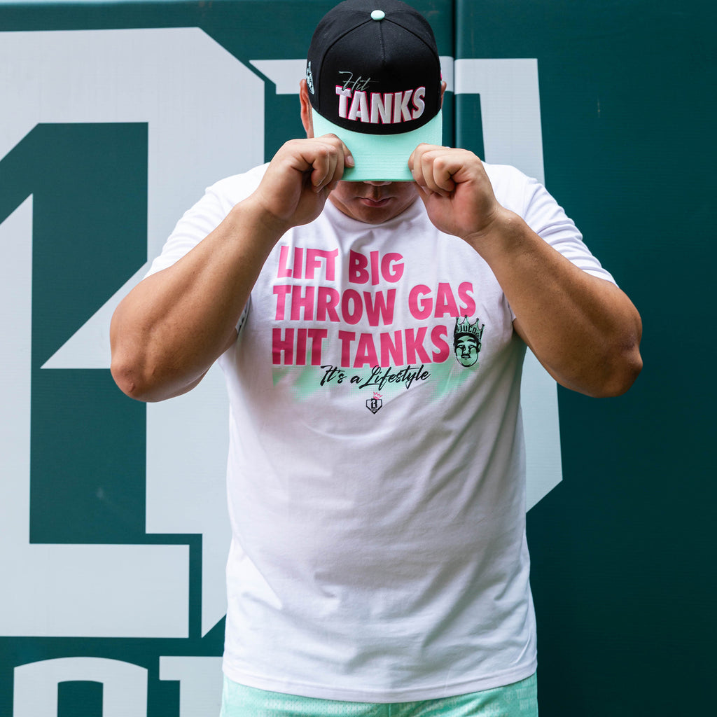 Adult model wearing white graphic tee with "Hit Tanks" design