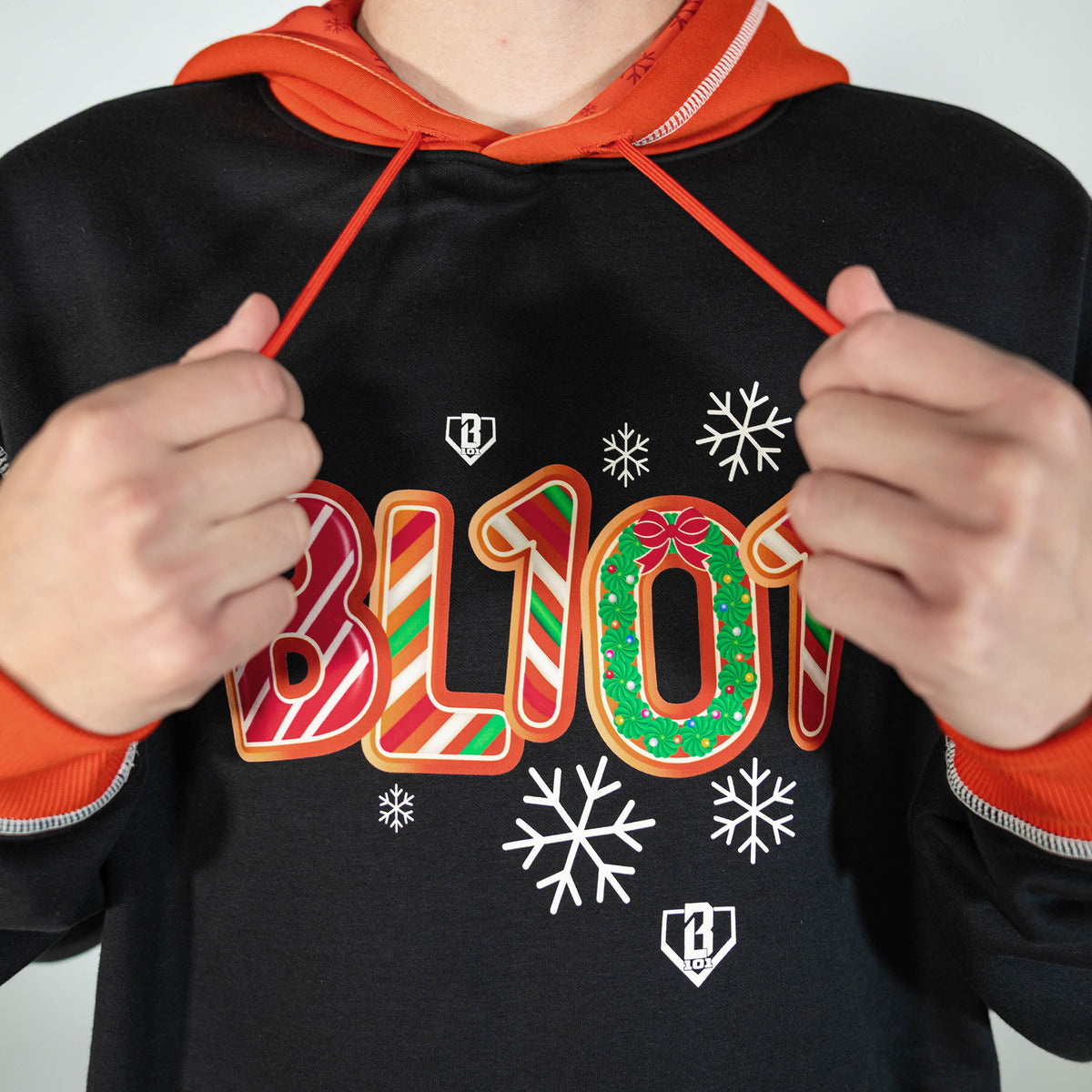 Adult model wearing black hoodie with "Holiday Cookie" design