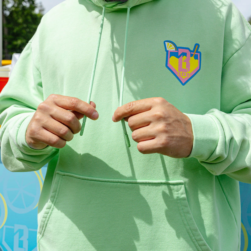 Adult model wearing green hoodie with "Lemonade" design