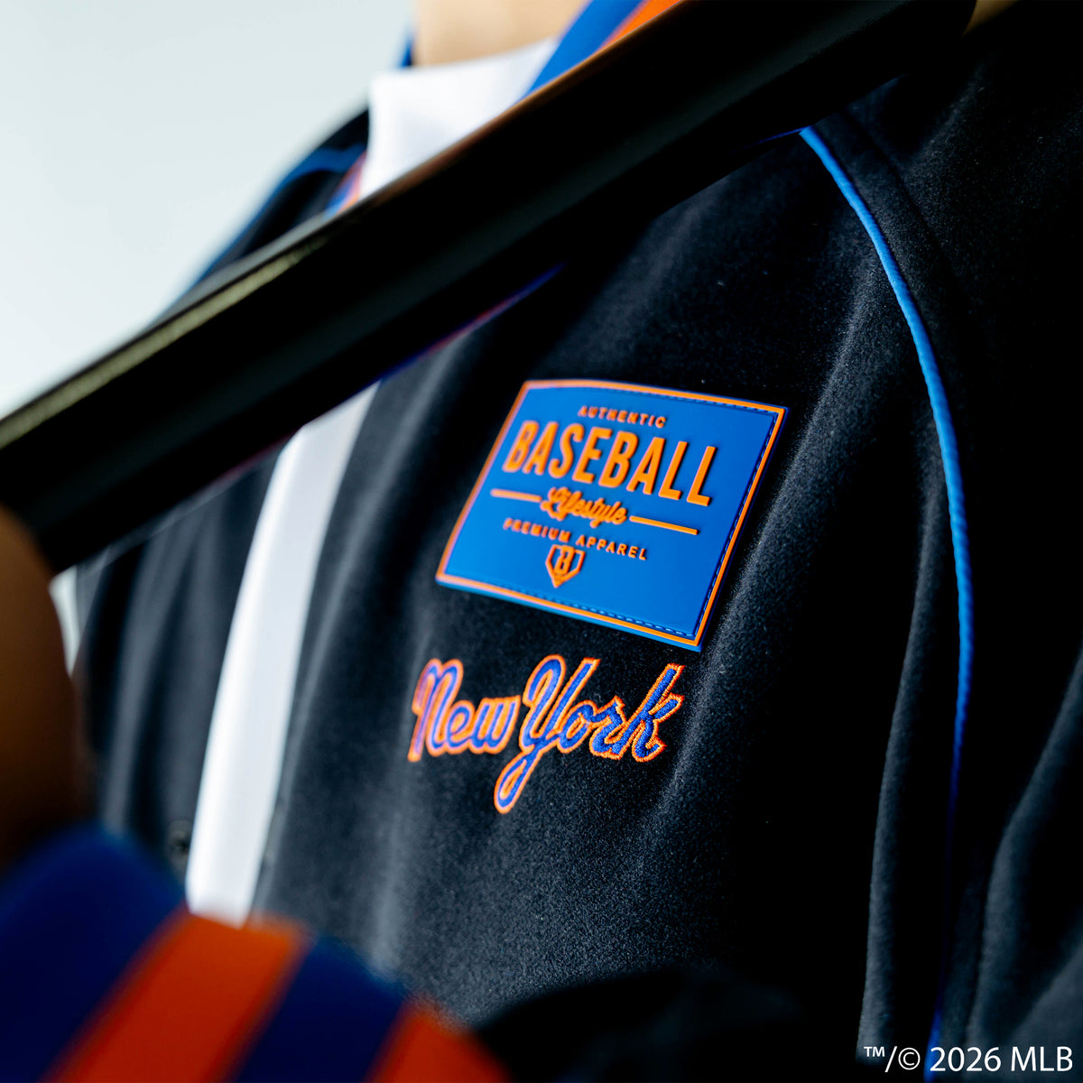 Adult model wearing black New York Mets Stadium bomber jacket