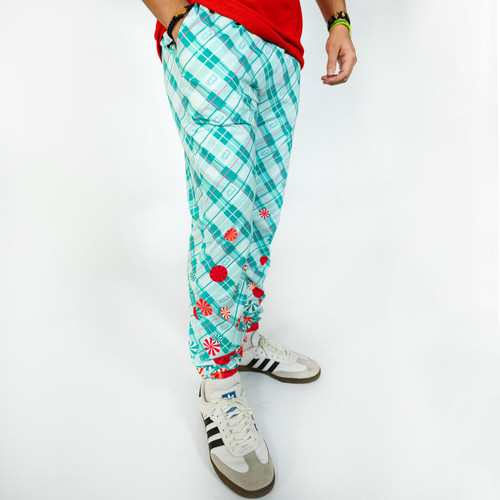 Adult model wearing multi-color pajama pants with "Peppermint Plaid" design