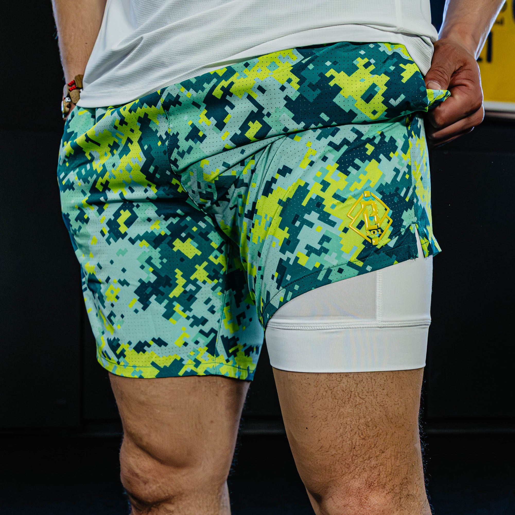 Person wearing green and blue camouflage shorts with white liner.