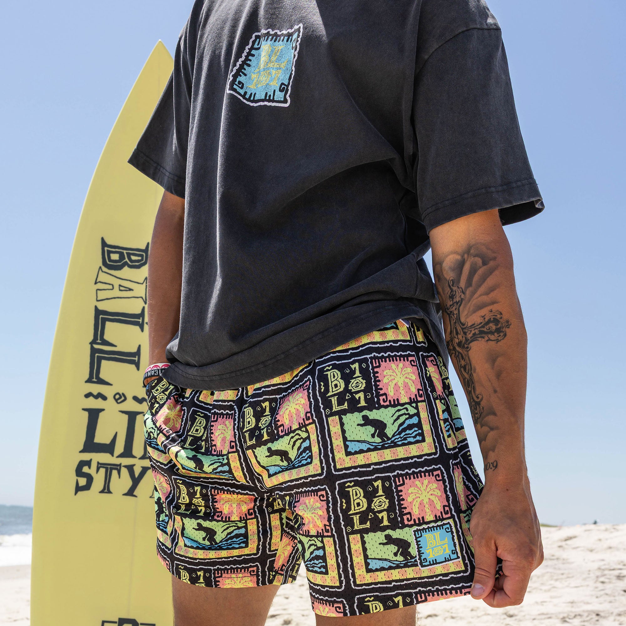 Adult model wearing multi-color shorts with "Wave Goodbye" design