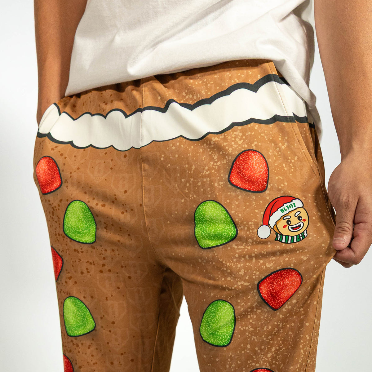 Adult model wearing brown pajama pants with "Gingerbread Rookie" design