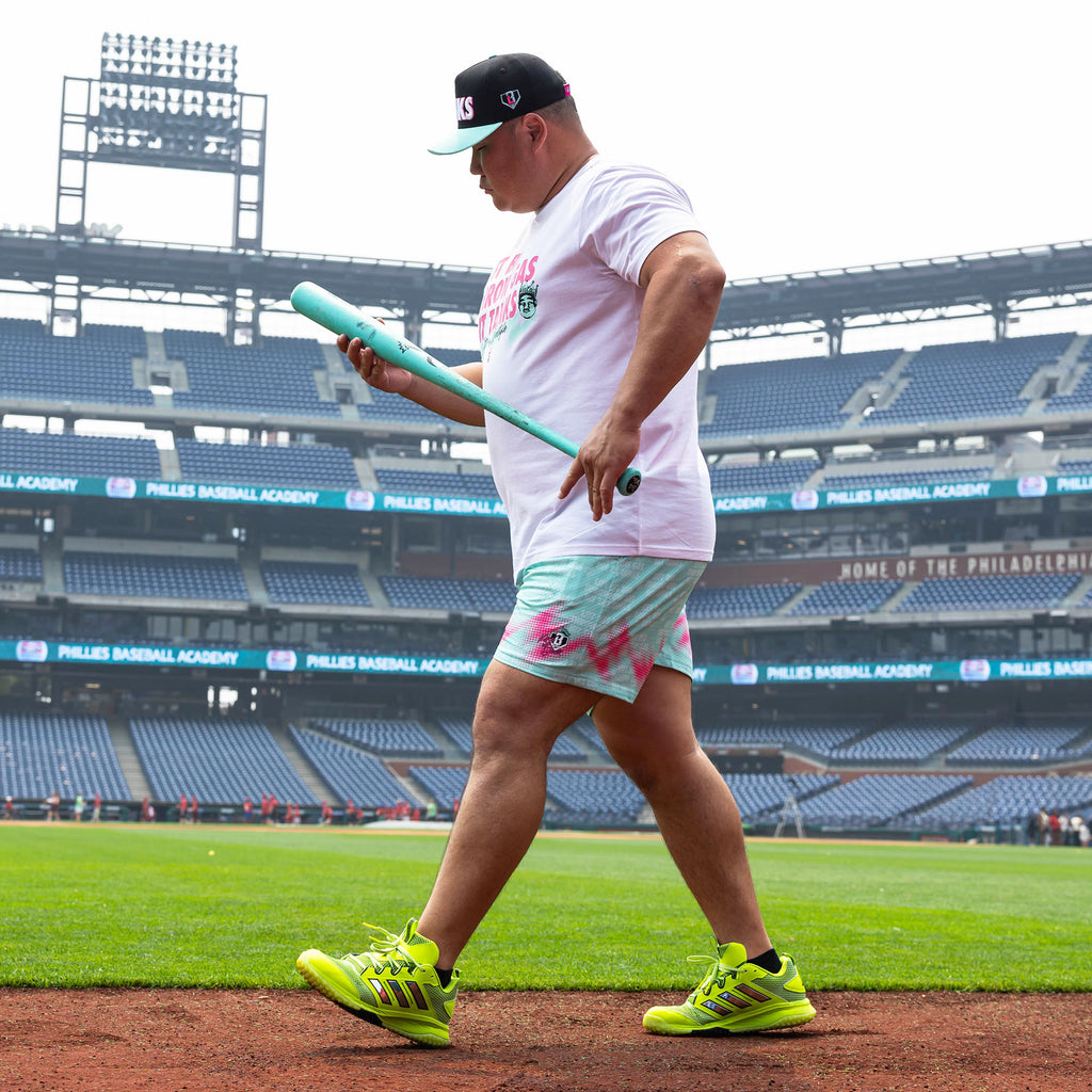 Adult model wearing teal shorts with "Hit Tanks" design