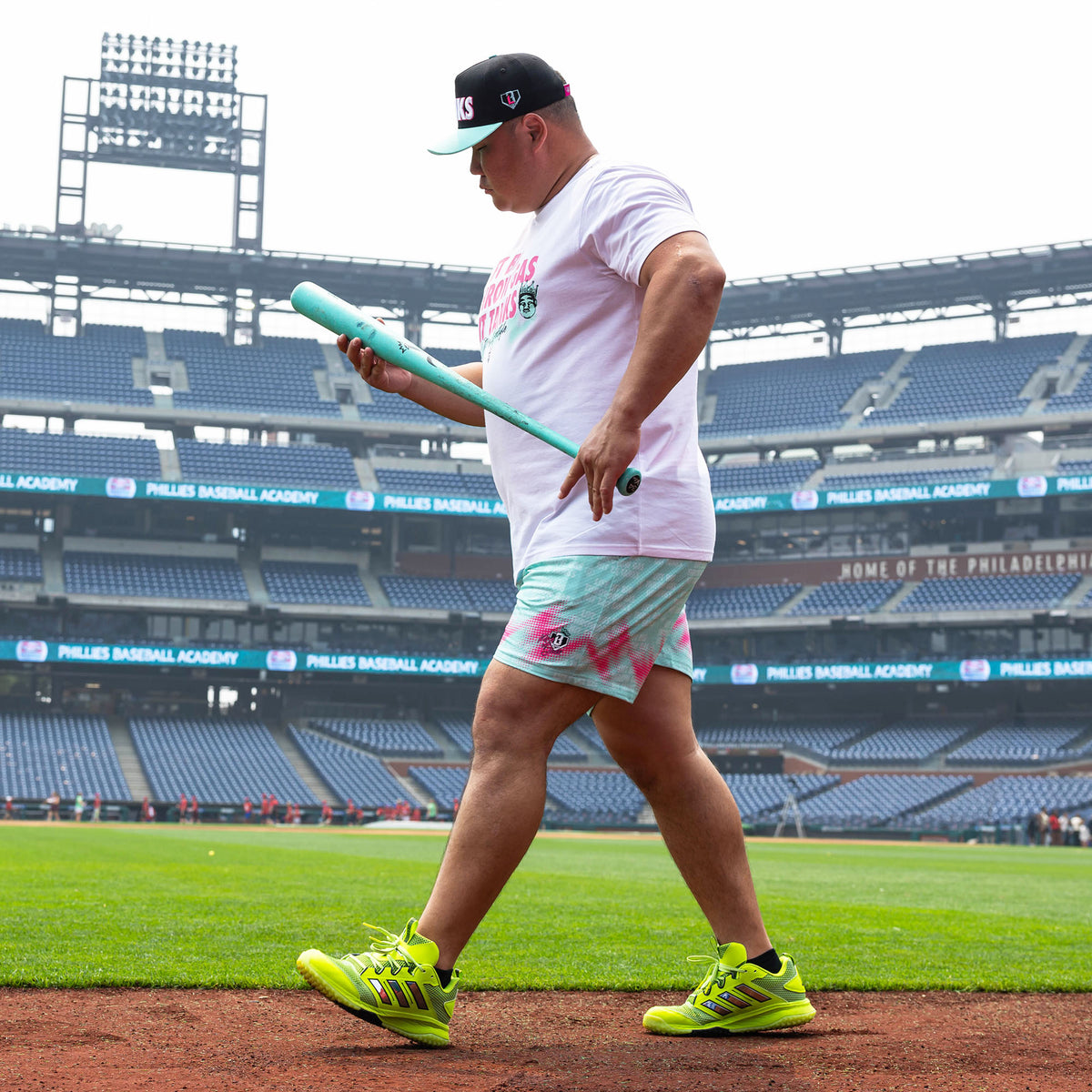 Adult model wearing teal shorts with "Hit Tanks" design