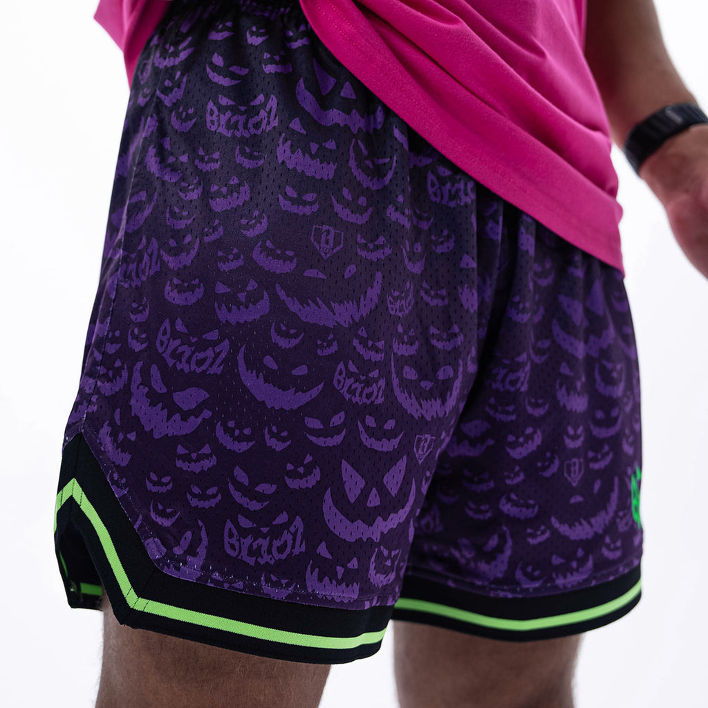 Adult model wearing purple shorts with "Jack O' Lantern Team" design