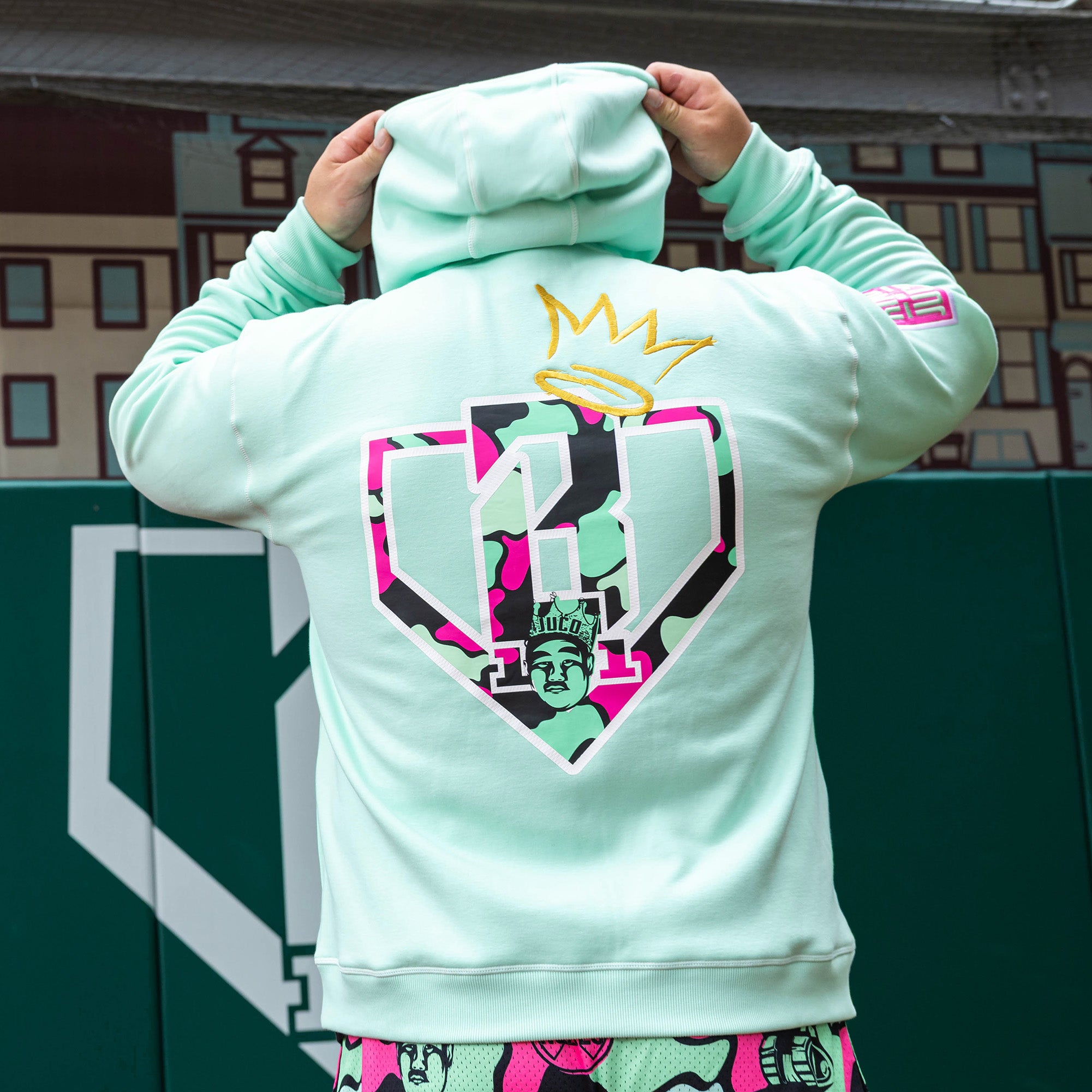 Adult model wearing teal hoodie with "King Of JUCO" design