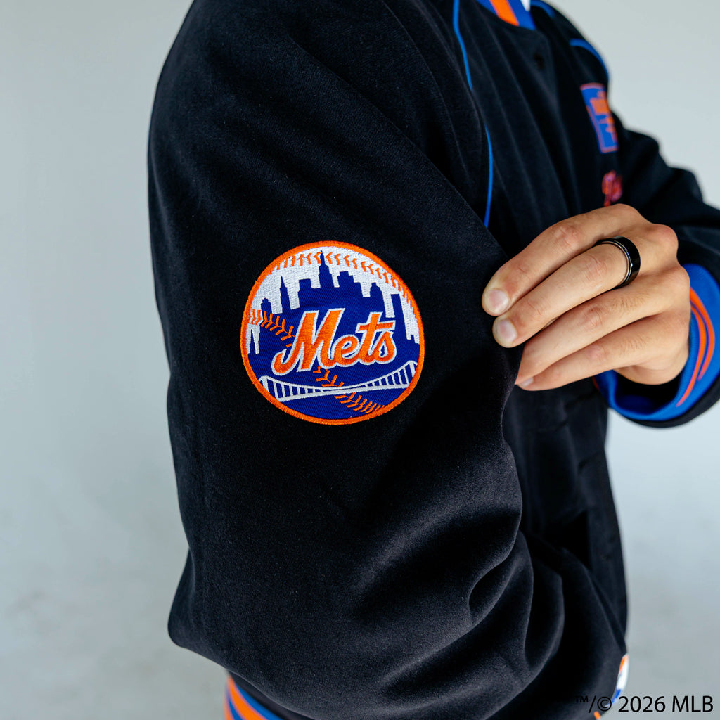 Youth model wearing black New York Mets Stadium youth bomber jacket