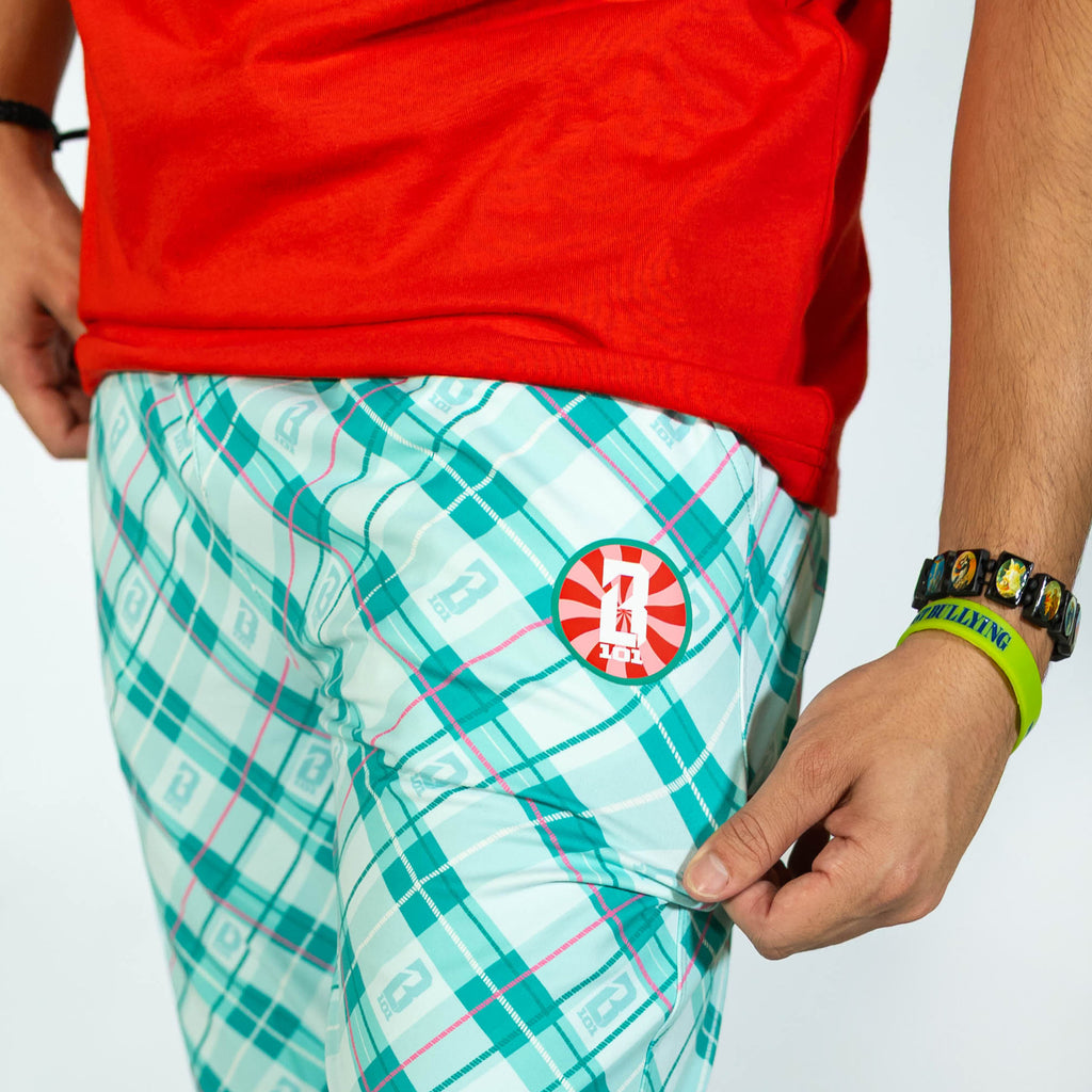 Adult model wearing multi-color pajama pants with "Peppermint Plaid" design