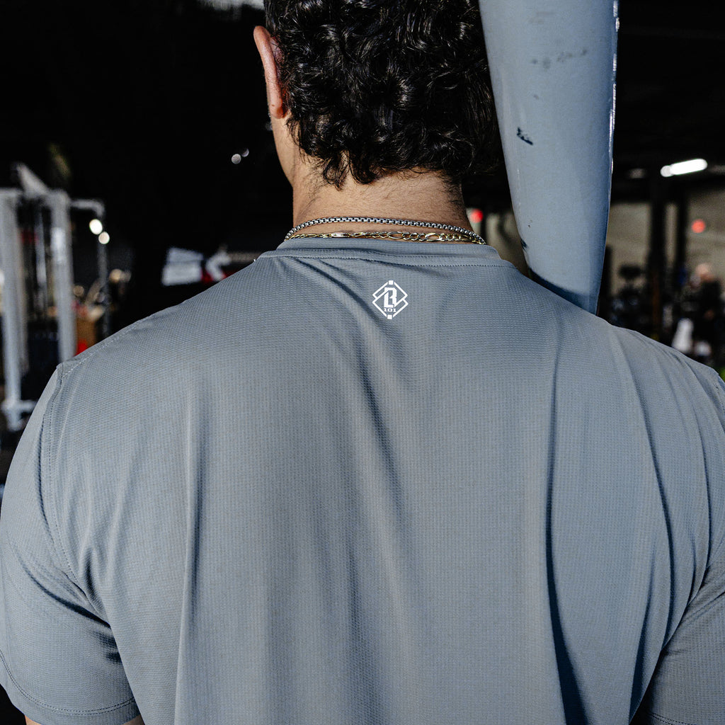 Person wearing a gray t-shirt with a logo on the back.