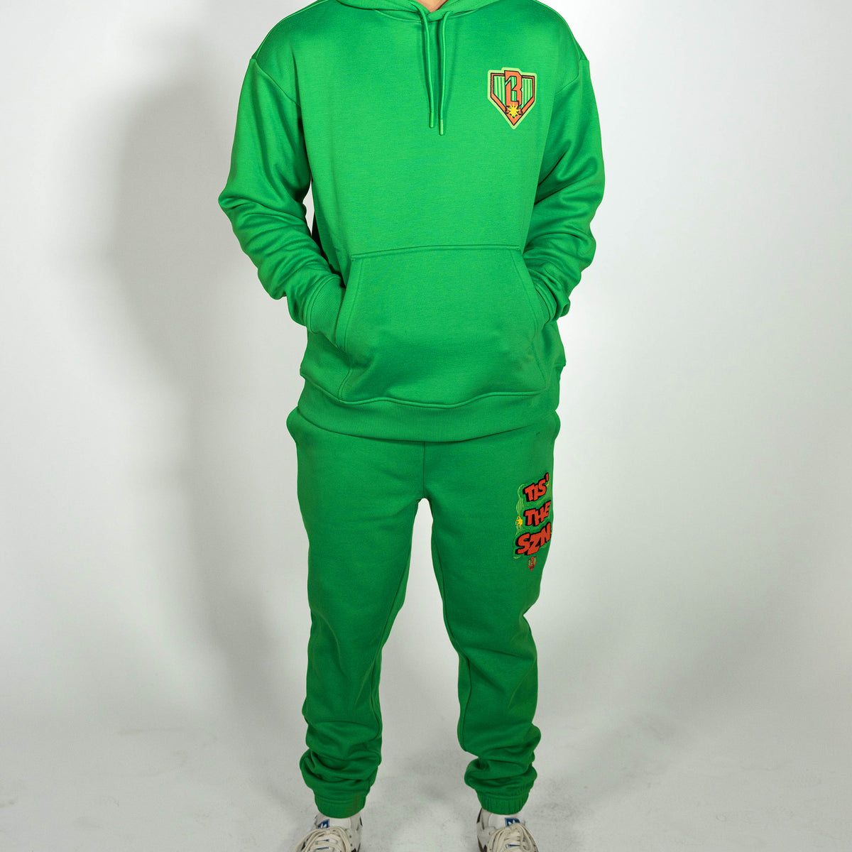 Adult model wearing green sweatpants with "Tis The SZN" design