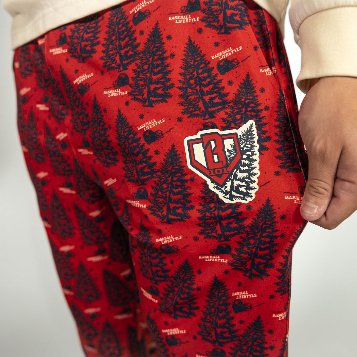 Adult model wearing red pajama pants with "Deck The Halls" design