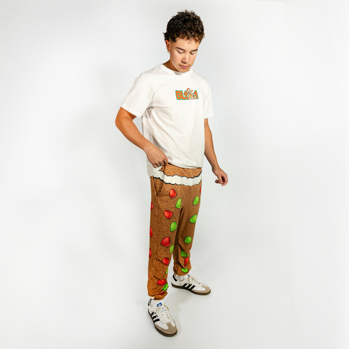 Adult model wearing brown pajama pants with "Gingerbread Rookie" design
