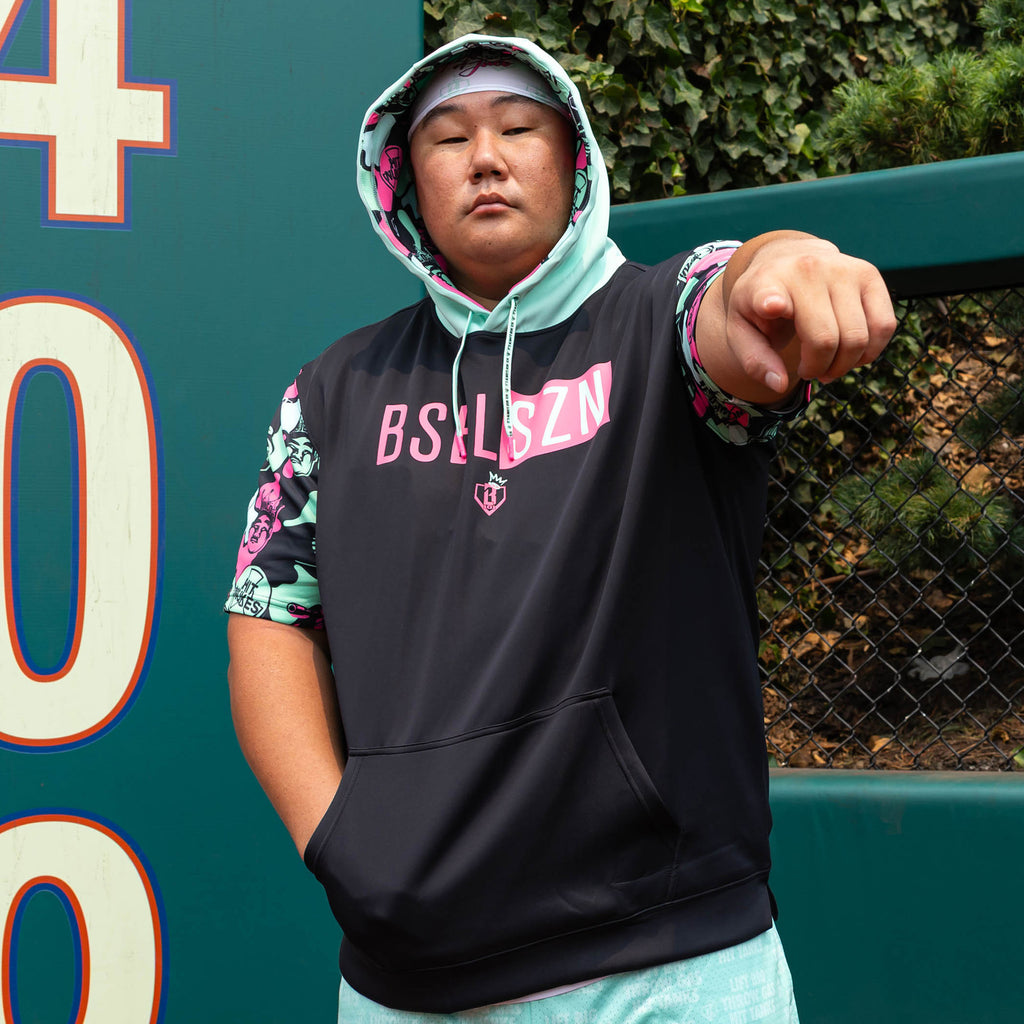 Adult model wearing black short sleeve hoodie with "King Of JUCO BSBL-SZN V3" design