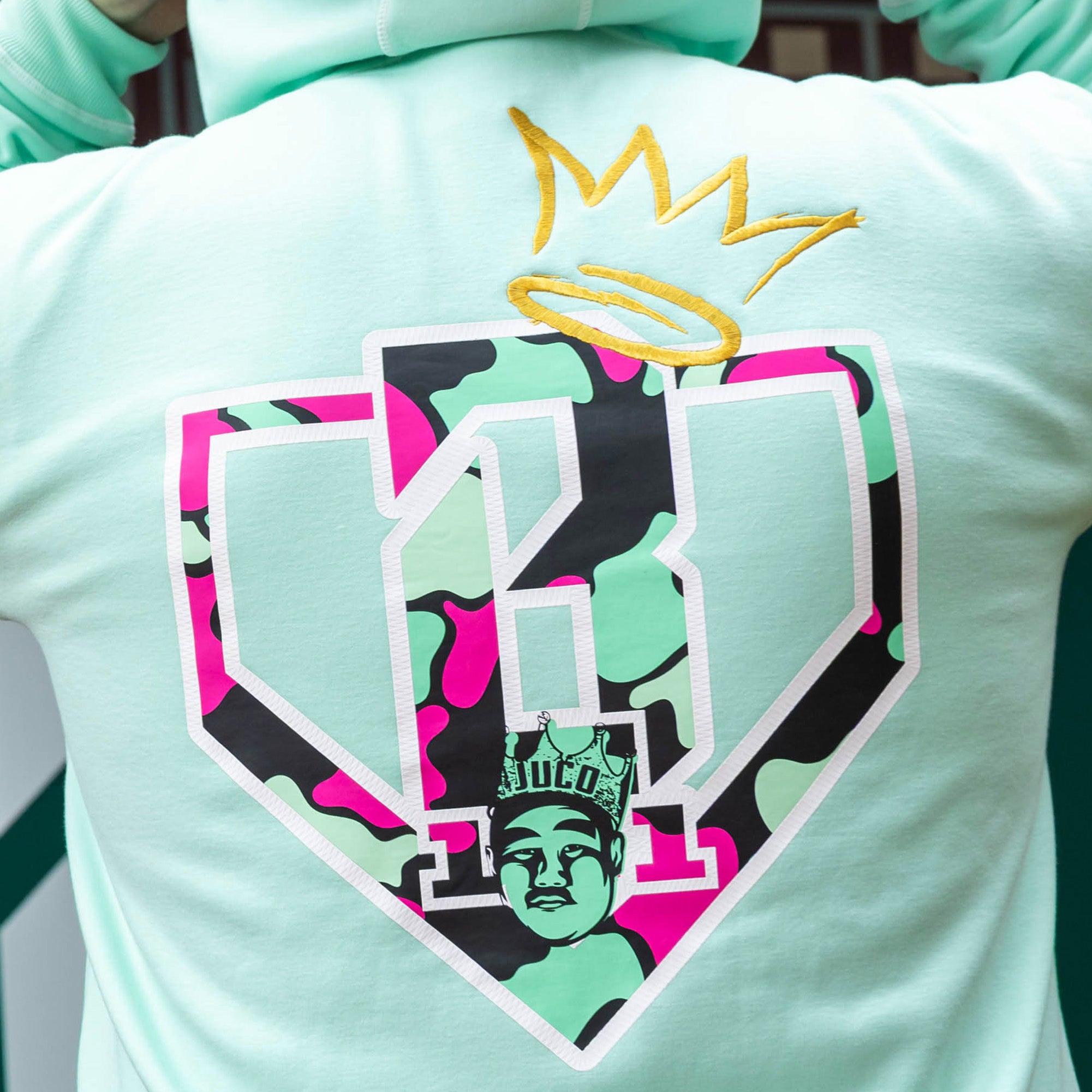 Adult model wearing teal hoodie with "King Of JUCO" design