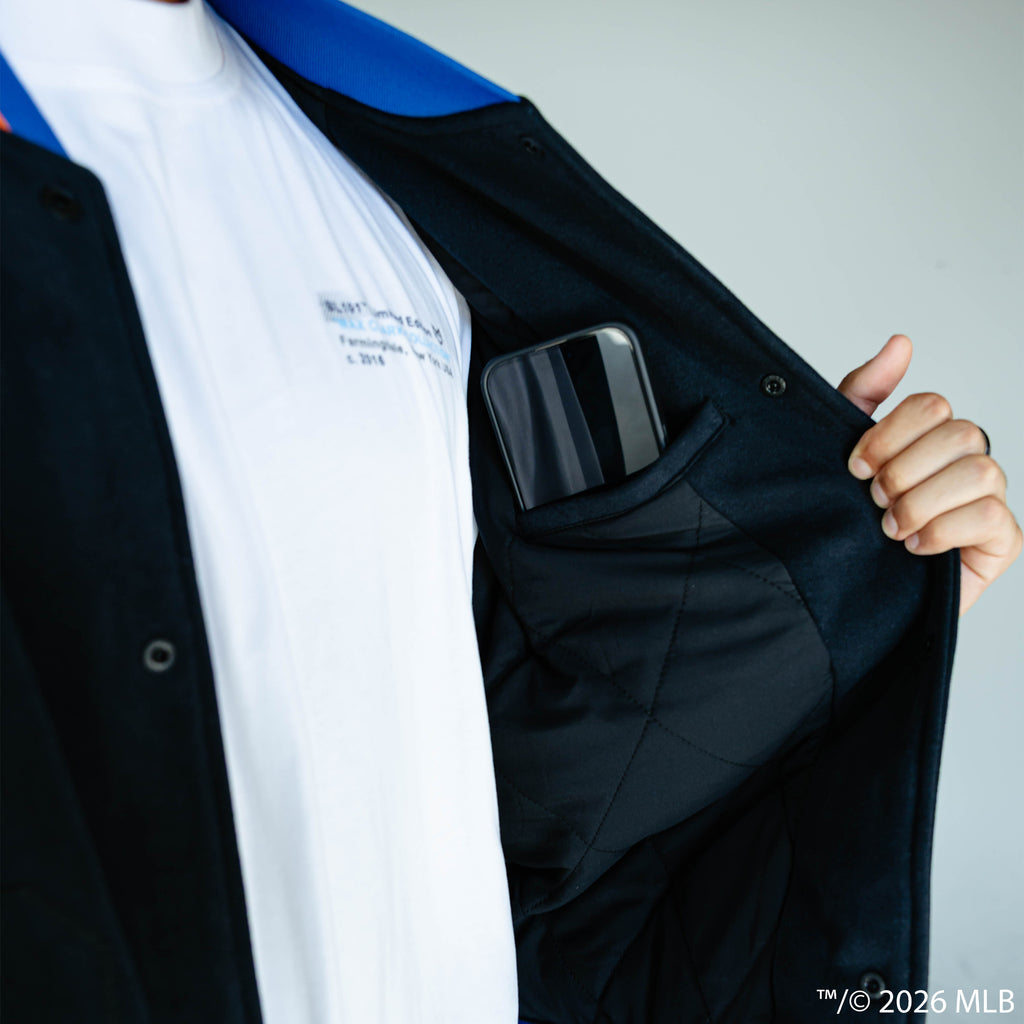 Adult model wearing black New York Mets Stadium bomber jacket