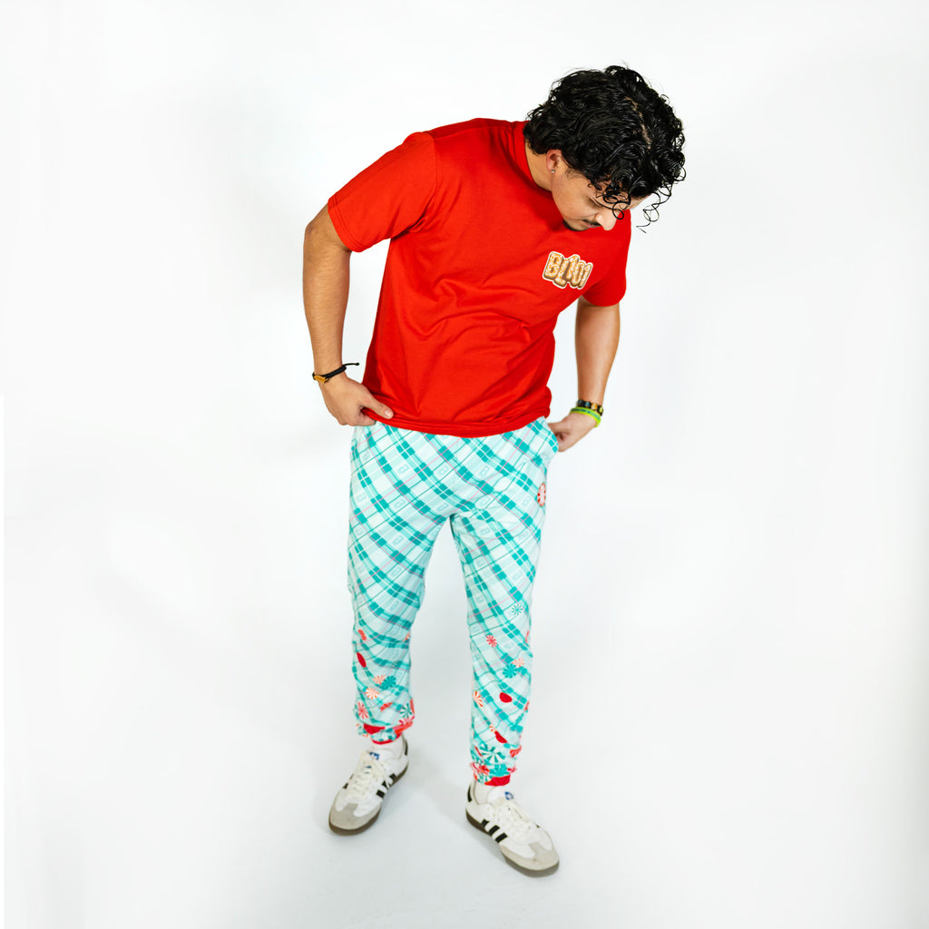 Adult model wearing multi-color pajama pants with "Peppermint Plaid" design
