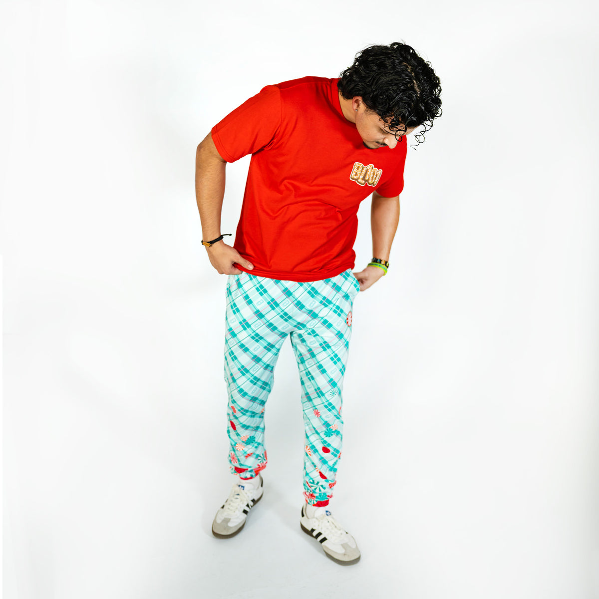 Adult model wearing multi-color pajama pants with "Peppermint Plaid" design