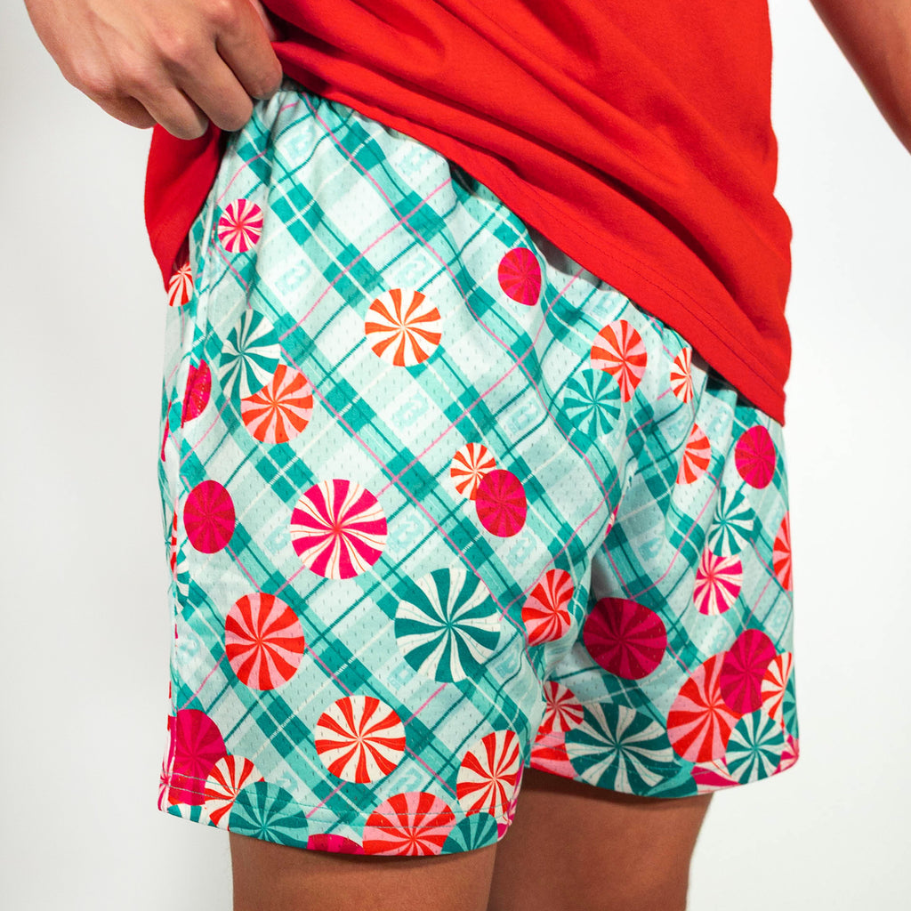 Adult model wearing teal shorts with "Peppermint Plaid" design