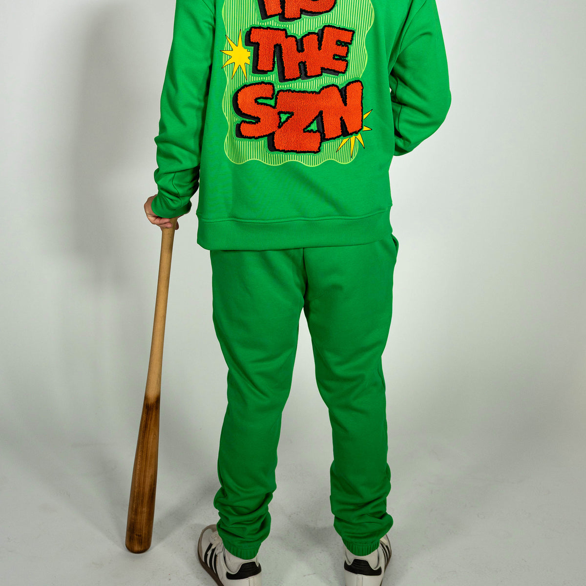 Adult model wearing green sweatpants with "Tis The SZN" design
