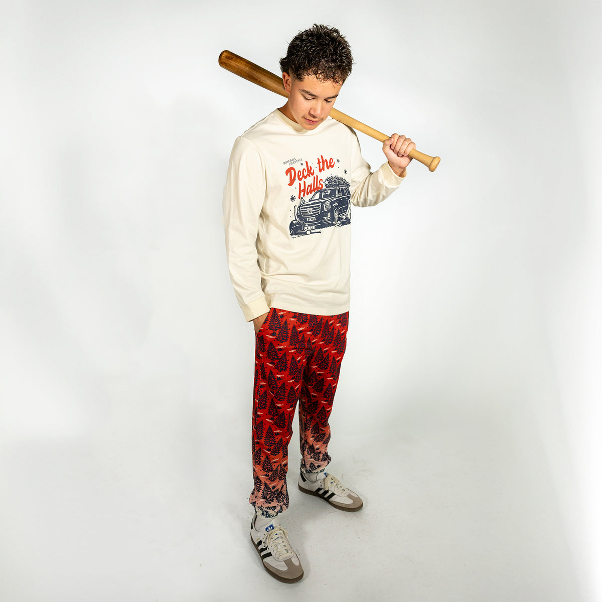 Adult model wearing red pajama pants with "Deck The Halls" design